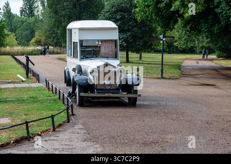 London, UK 07 Juli 2025 Vintage-Food-Truck und Menschen, die auf einem Fußweg im hyde Park spazieren Stockfoto