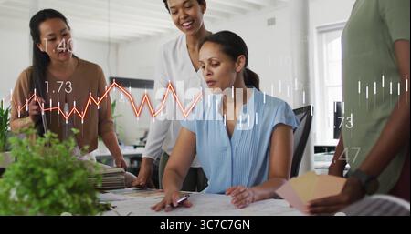 Zeigende Frau in hellblauer Bluse, die im Studio den Entwurf überprüft, mit Farbfeldern und Datenüberlagerung Stockfoto
