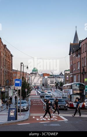 25. Juli 2025 Cork, Irland Eine geschäftige urbane Straßenszene voller Fußgänger und verschiedener Verkehrsaktivitäten Stockfoto