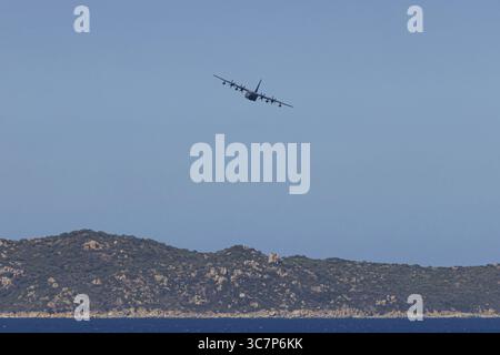 Eine Lockheed Martin MC-130J Commando II, ein Militärflugzeug der US Air Force, fliegt tief über Costa Rei, einem Küstengebiet der italienischen Mittelmeerinsel Stockfoto