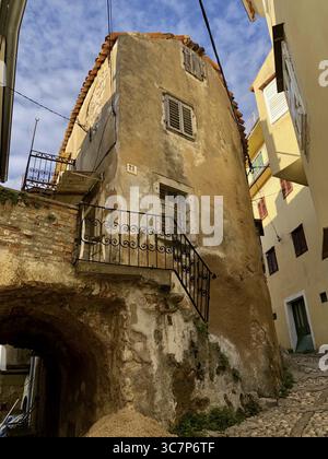 Historisches Gebäude in einer Gasse mit steilen Straßen und alten Mauern, Vrbnik, Insel Krk, Kroatien Stockfoto