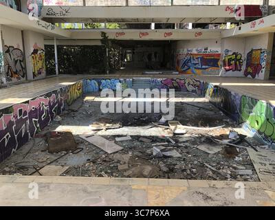 Verlassener Swimmingpool mit Graffiti und Betonresten, umgeben von zerstörten Bauten, verlorener Ort, ehemaliges Palace Hotel Haludovo auf Krk, Kroatisch Stockfoto