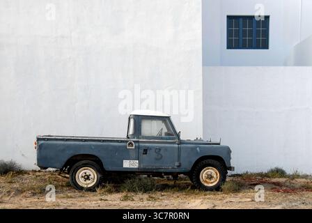Der alte blaue Pickup-Truck parkte im Mai 2011 in La Graciosa, Spanien, in der Nähe der weißen Mauer Stockfoto
