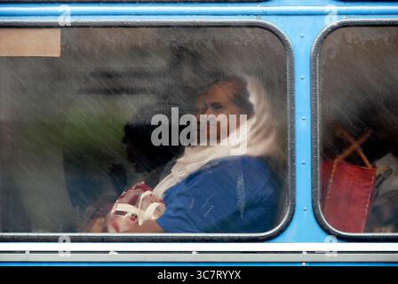 Eine Frau schaut aus einem nebeligen Fenster eines öffentlichen Busses in Mauritius, März 2017. Stockfoto