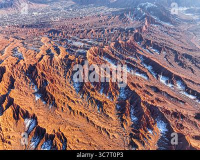 Eine atemberaubende Hochwinkelaufnahme zeigt das dramatische rot-braune Gelände des Mars Canyon mit seinen komplizierten Formationen und leichtem Schnee auf dem Boden Stockfoto
