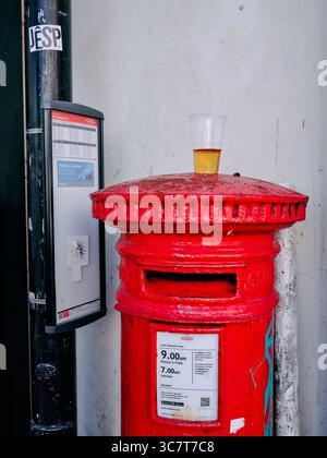 Eine Bushaltestelle, ein roter Postkasten und ein Plastikglas Lager aus der Vornacht in Falmouth, Cornwall England, Großbritannien Stockfoto