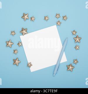 Leere Grußkarte für Ihren Text mit Stift und dekorativen Sternen auf cyanfarbenem Hintergrund Stockfoto
