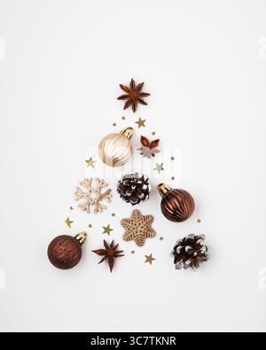 Silhouette eines Weihnachtsbaums aus Kugeln, Schneeflocken, Kegeln, Sternanis und Konfetti auf weißem Hintergrund. Eine Idee für das neue Jahr. Stockfoto