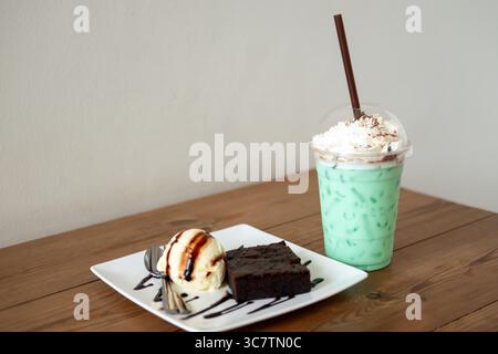 Geeiste Minzschokolade in einer Tasse mit Brownie und Eis auf dem Tisch Stockfoto