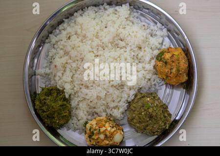 Traditionelles bengalisches Essen (Bangladesch) auf einem Stahlteller. Weißer Reis mit vier Arten von Vorta wie Aloo Bharta, Ei Bharta, Chepa Shutki Bharta und SH Stockfoto
