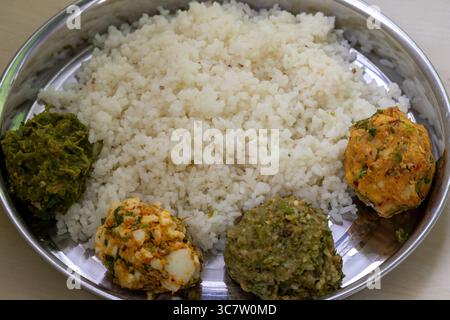 Traditionelles bengalisches Essen (Bangladesch) auf einem Stahlteller. Weißer Reis mit vier Arten von Vorta wie Aloo Bharta, Ei Bharta, Chepa Shutki Bharta und SH Stockfoto