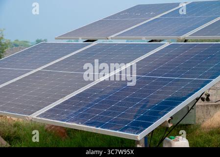 Solarbetriebene Panels werden auf landwirtschaftlichen Flächen, Feldern oder Farmen installiert. Reihen von Solarpaneelen mit nachhaltiger Energie, die auf landwirtschaftlichen Wiesen auf dem ländlichen Feld installiert sind Stockfoto