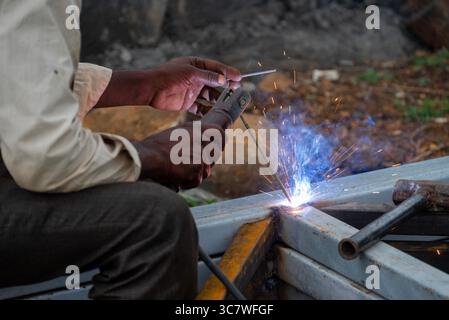 Indischer Arbeiter, der Schweißen macht. Close-up-Metallarbeiter-Schweißeisen in einer Werkstatt Stockfoto