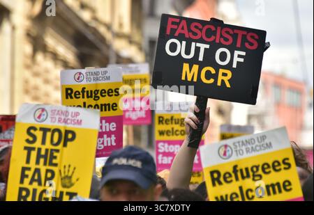 Manchester, Großbritannien, 2. August 2025. Großbritannien der erste märz von etwa 600 Menschen, die „Remigration fordern“, begann in der Nähe der Piccadilly Station in Manchester, Großbritannien, zu Fuß zum St. Peter's Square. Kritiker sagen, dass Großbritannien zuerst eine rechtsextreme, anti-muslimische und einwanderungsfeindliche Gruppe ist, die 2011 von ehemaligen Mitgliedern der British National Party gegründet wurde. Die Gruppe „Stand Up to Rassismus“ hielt eine Kundgebung als Gegenprotest ab. Viele Polizisten hielten die beiden Seiten auseinander. Ein Gegenprotestierender hält ein Plakat mit dem Titel "Faschisten aus MCR". Quelle: Terry Waller/Alamy Live News Stockfoto