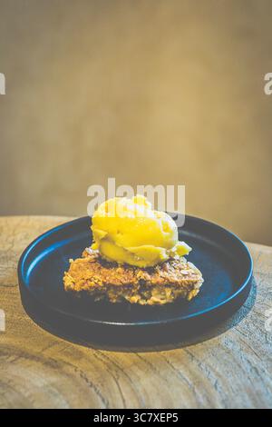 Apfelstreusel mit Mango-Sorbet Granny Smith Apfelstreusel mit warmer, gewürzter Füllung und knuspriger Platte, serviert mit Mangosorbet Stockfoto