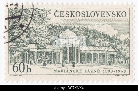 TSCHECHOSLOWAKEI - 25. Juni 1958: 60 haléř graugrüne Briefmarke mit Blick auf Marianske Lazne (Marienbad). Herausgegeben, um tschechoslowakische Heilbäder zu veröffentlichen. Mariánské Lázně ist ein Kurort im Bezirk EEG in der Region Karlsbad in der Tschechischen Republik. Die meisten Gebäude der Stadt stammen aus der goldenen Ära in der zweiten Hälfte des 19. Jahrhunderts, als viele Berühmtheiten und europäische Spitzenherren kamen, um die heilenden Kohlendioxidquellen zu genießen. Das Stadtzentrum mit der Kurlandschaft ist gut erhalten und als städtisches Denkmalschutzgebiet geschützt Stockfoto