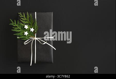 Schwarze Geschenkbox mit weißem Band und Thuja mit Platz für Ihren Text Stockfoto