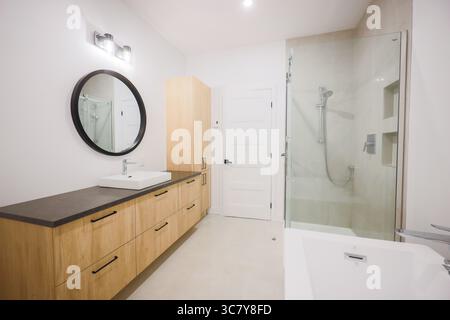 Ein sauberes, gut beleuchtetes Badezimmer in einem Haus mit moderner Einrichtung und minimalistischem Design. Stockfoto