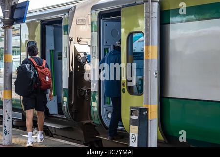 25. Juli 2025 Passagiere aus Cork, Irland steigen an einem belebten und belebten Bahnhof in einen Zug ein, der voller Aktivität und Energie ist Stockfoto