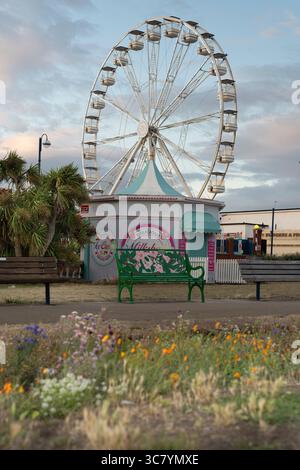 Der Barry Island Pleasure Park, Wales, bietet einen malerischen Blick auf das Riesenrad und die Imbissstände und lädt Besucher ein, klassische Köstlichkeiten und Fahrgeschäfte am Meer zu genießen. Stockfoto