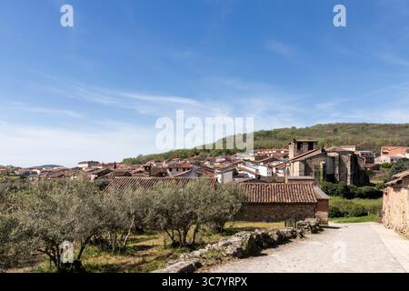 Charmantes spanisches Dorf, eingebettet in sanfte Hügel, von einem Olivenhain aus gesehen an einem hellen, sonnigen Tag Stockfoto