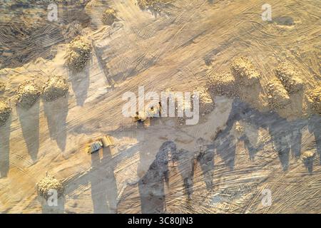 Erdbewegungsgeräte in einer Bauzone. Industriemaschinen, die auf einer Baustelle arbeiten. Draufsicht der Antenne Stockfoto