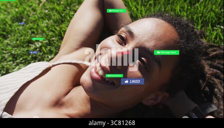 Eine lügende Frau mit gestreiftem Oberteil, die auf grünem Gras zusieht, mit schwebender Nachricht gesendet, gefällt Abzeichen Stockfoto