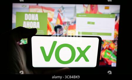 Deutschland. Juli 2025. In dieser Abbildung hält eine Person ein Handy mit dem Logo der spanischen politischen Partei Vox auf dem Bildschirm vor der Webseite. Quelle: SOPA Images Limited/Alamy Live News Stockfoto