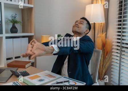 Geschäftsmann im Büro entspannen im Büro, ruhiger Geschäftsmann sitzen entspannen in seinem privaten Büro Arbeitsplatz machen eine Pause, glücklich entspannt jung, Mann, Asiatisch Stockfoto