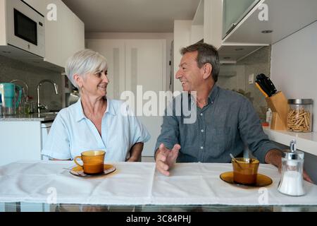 Seniorenpaar genießt Kaffee und Unterhaltung in der Küche Stockfoto