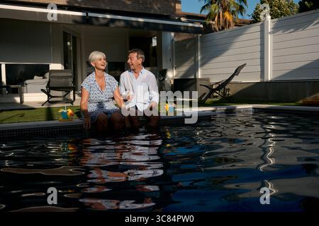 Seniorenpaar, das sich am Pool entspannt und gemeinsam den Ruhestand genießt Stockfoto