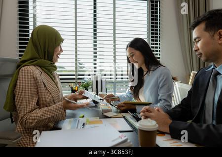 Eine Gruppe von Geschäftsleuten diskutiert in einem Büro. Geschäftsleute unterschiedlicher Kultur treffen sich, um Produkte herzustellen, die angemessen und religiös sind Stockfoto