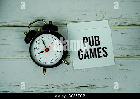 Pub Games Textnachricht auf Papier mit Wecker auf hölzernem Hintergrund Stockfoto