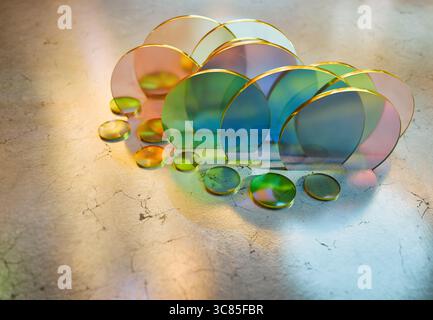 3D-Rendering der Anordnung von transparenten Glasscheiben und Lichtbögen, die bunte Schatten auf eine gerissene Marmoroberfläche werfen Stockfoto