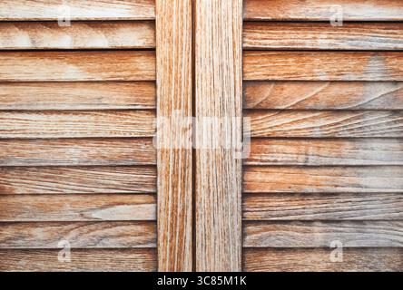 Holzläden in Nahaufnahme. Türen mit dünnen Querplatten und dazwischen liegenden Öffnungen. Holztüren. Stockfoto