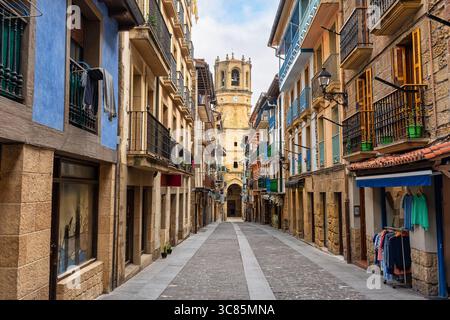 Hauptstraße des historischen Zentrums von Getaria mit alten Gebäuden und der Kirche San Salvador am Ende der Straße, Baskenland Stockfoto