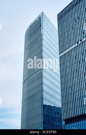 Moskau, Russland - 17. Juli 2025: Zwei moderne Wolkenkratzer aus Glas und Stahl mit vertikalen Linien und Reflektionen des blauen Himmels Stockfoto