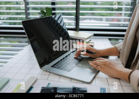 Geschäftsfrau, die in ihrem Studio an einem Laptop arbeitet, Geschäftsfrau, die an einem digitalen Tablet arbeitet, und Laptop im Büro, geschäftige, professionelle Führungskraft Stockfoto