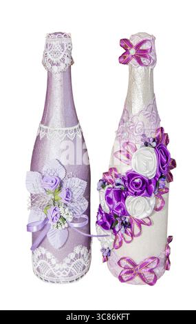 Zwei wunderschön dekorierte Weinflaschen zeigen komplizierte Designs mit Spitze und floralen Akzenten in violetten Tönen. Perfekt für Geschenke oder elegant Stockfoto