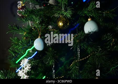 Ein wunderschön dekorierter Weihnachtsbaum mit blauen und goldenen Ornamenten und bunten Lichtern. Die festliche Dekoration sorgt für eine warme Atmosphäre Stockfoto