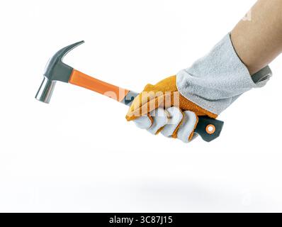 Ein handtragender Lederhandschuh hält den Hammer mit orangefarbenem Griff fest, der vor weißem Hintergrund steht und ein Gefühl von Bereitschaft und Stärke vermittelt Stockfoto