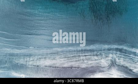 Türkisfarbenes Wasser trifft sanft auf markante Sandstrände der Färöer. Tjornuvik Dorf, Blick auf das Meer und den Strand von oben Stockfoto