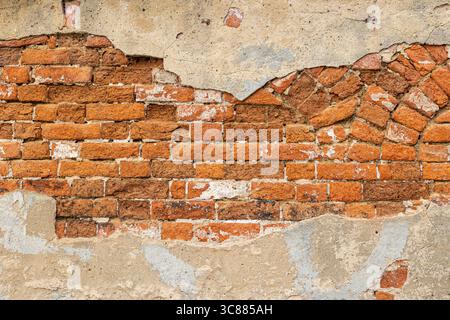 Freiliegende Backsteine auf einem alten mittelalterlichen Gebäude in Europa bilden ein interessantes Hintergrundelement. Stockfoto