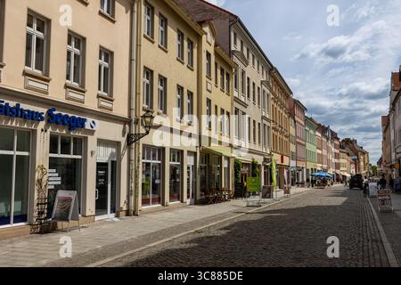 Wittenberg, Deutschland - 8. Mai 2025: Am 8. Mai 2025 in Wittenberg wird ein Stadtblock mit bunten Pastellgebäuden entlang einer Kopfsteinpflasterstraße gesäumt. Stockfoto