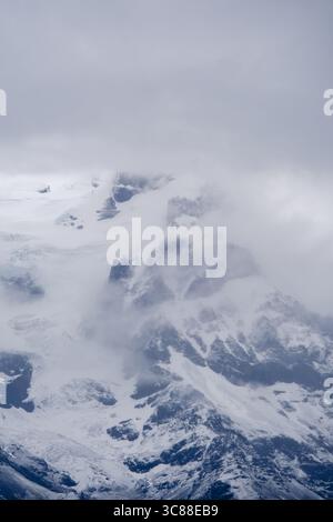 Spektakuläre Aussicht auf den Svinafellsjokull-Gletscher mit seiner eisigen Masse und zerklüfteten Berggipfeln unter einem dramatischen bewölkten Himmel. Eine wahre Darstellung der atemberaubenden Naturschönheit Islands. Stockfoto