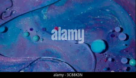 Ölflüssigkeit. Druckfarbe. Unschärfe blau lila rosa bunte Fluss Glitzer Blasen flüssige runde Textur, die auf abstraktem Acrylhintergrund verbreitet wird. Stockfoto