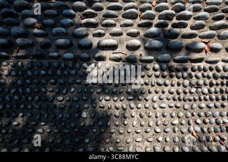 Nahaufnahme großer und kleiner Kieselsteine. Fußreflexologie im öffentlichen Raum auf einem Wohngebiet Singapur. Stockfoto