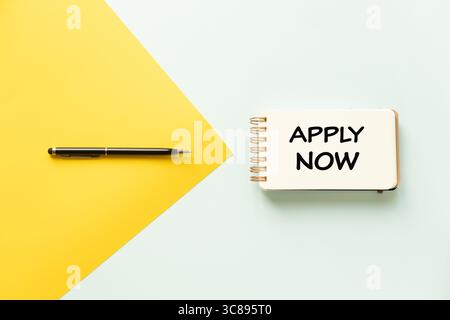 Jetzt bewerben. Konzeptionelle Wörter, unternehmensspezifische Sätze, ein gelber Pfeil und ein schwarzer Stift zeigen auf ein Notizbuch mit den Worten „jetzt anwenden“. Geschäftskonzept: Wir V Stockfoto