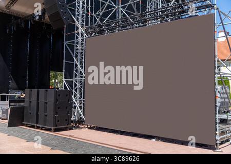 Ein großer modularer LED-Bildschirm zeigt während eines energiegeladenen Open-Air-Konzerts lebendige Videoaufnahmen an und beleuchtet die Nacht mit dynamischen Grafiken. Stockfoto