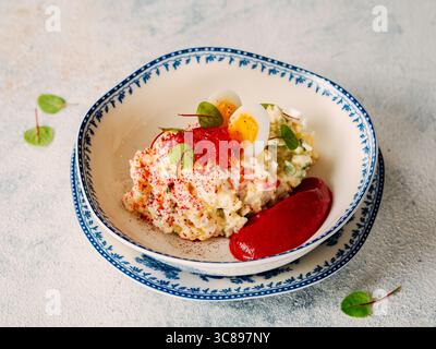 Mayonnaise-Salat mit Krabbenfleisch, dekoriert mit Rote-Bete-Mousse in Restaurantstil. Nachgeahmter Krabbensalat mit Krabbenstangen oder Krabbenfleisch und z. B. Stockfoto